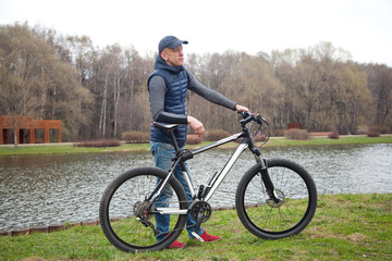 Obraz premium the young man with bicycle in the park in the spring