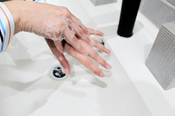 Woman washing her hands with soap and water to avoid Corona Virus Covid 19