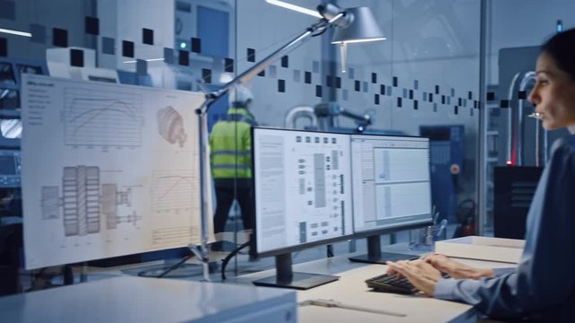 In Factory: Professionals Working on CNC Machinery, Walk Through Workshop, Use Digital Tablet, Manipulate Robot Production Line. In-Office: Female Engineer Controls System with Computer. Moving Camera