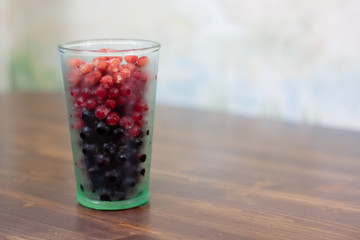 frozen berries. raspberries, black and red currants. on a wooden table