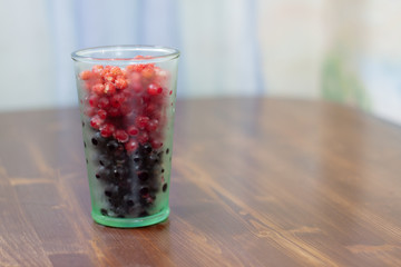 frozen berries. raspberries, black and red currants. on a wooden table