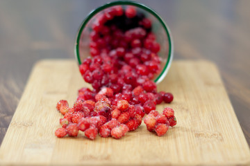 frozen berries. raspberries, black and red currants. on a wooden table