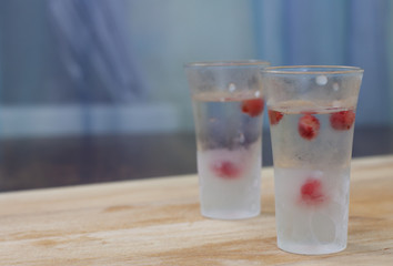 ice-cold vodka glasses with raspberries and currants on a wooden stand
