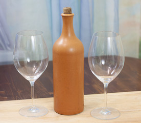 a bottle of homemade wine with two glasses on the table
