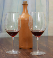 a bottle of homemade wine with two glasses on the table