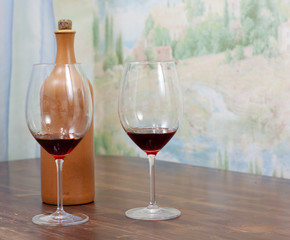 a bottle of homemade wine with two glasses on the table