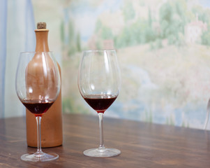 a bottle of homemade wine with two glasses on the table