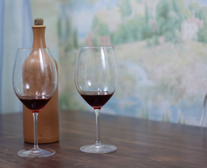 a bottle of homemade wine with two glasses on the table