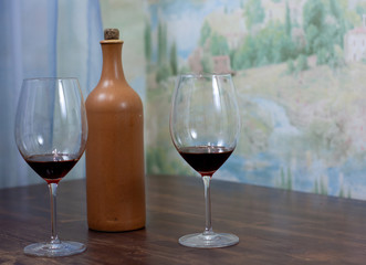 a bottle of homemade wine with two glasses on the table