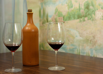 a bottle of homemade wine with two glasses on the table