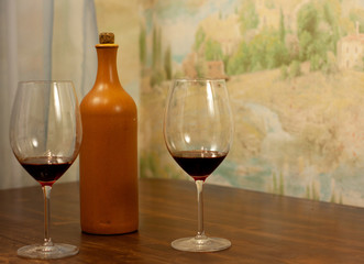 a bottle of homemade wine with two glasses on the table