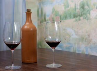 a bottle of homemade wine with two glasses on the table
