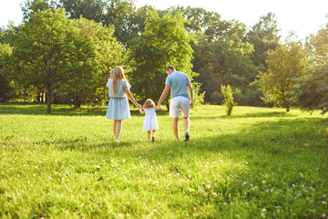 Naklejka na ściany i meble Happy family with children in the park at sunset.