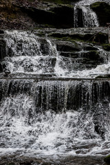 Little waterfall down the canyon in the middle of the green forest