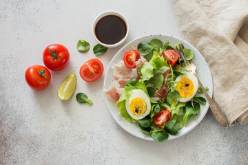 Boiled eggs, bacon and mix of salad leaves
