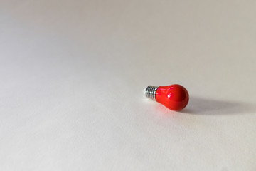 Small red light bulb top view on white background