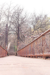 Old pedestrian bridge with rusty railings and rusty poles