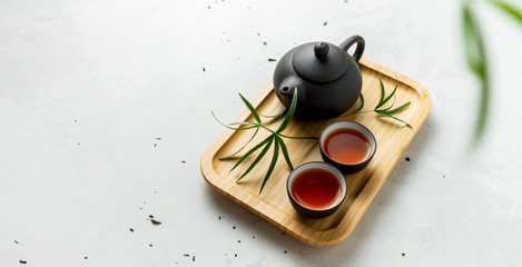 Tea set with cups and teapot with free space for text on white stone surface. Asian tea background.