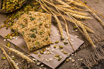Multigrain Cereal Crunchy Squares Bars with Pumpkin Seeds on Wooden Background. Selective focus.