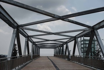 Steel construction from the bridge. Photography of modern steel bridge on the grey sky background.