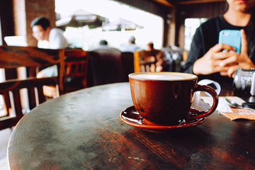 Latte coffee cup on wooden table in cafe