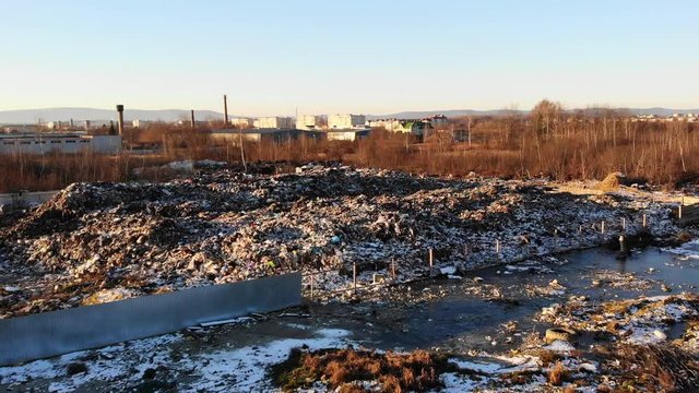 Flyover above of uncontrolled landfill on the outskirts of the city. Pollution and environmental threats. Drone view