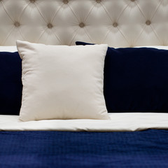 comfortable bed made with stylish blue and white pillows
