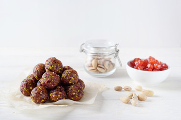 Energy balls with dried apricots, raisins, pistachios and dried cherrys. Vegan food. White background with copyspace from above. Middle view. Proper nutrition concept.
