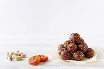 Energy balls with dried apricots, raisins, pistachios and dried cherrys. Vegan food. Good nutrition concept. White background with copyspace from above. Middle view.