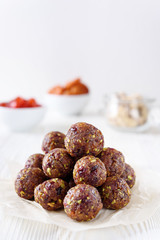 Energy balls with dried apricots, raisins, pistachios and dried cherrys. Vegan food. White background with copyspace from above. Proper nutrition concept.
