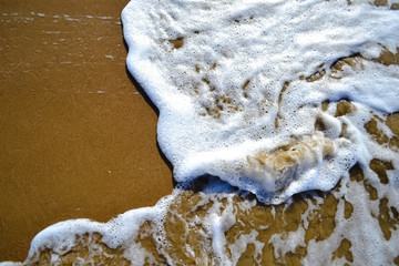 sea foam on a sandy beach,  copy space