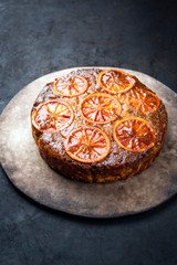 Traditional American upside-down bloody orange cake offered as closeup on a modern design tray with copy space