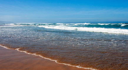 Storm on the beach. Sea long wave on a sandy beach.
