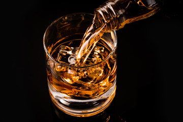 glass of whiskey on black background	