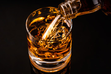 glass of whiskey on black background