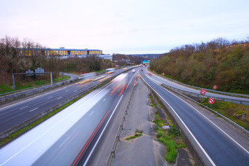 Moving by cars and trucks driving on a fast lane. Vehicles on the highway. Transport photographed in long exposure mode in lightpainting.