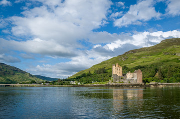 Fototapeta premium Eilean Donan Castle and scottish highlands landscape view from the water. Hebrides, Scotland.