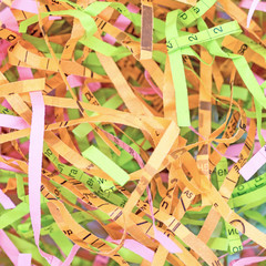 Close up of colorful paper strips from shredder, background and texture. Selective focus