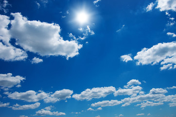 Blue sky with clouds and sun.