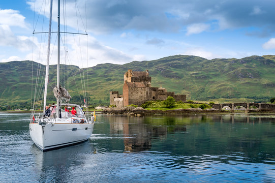Sailing yacht crew taking photos of Eilian Donan Castle. Inner Hebrides cruise, Scotland.