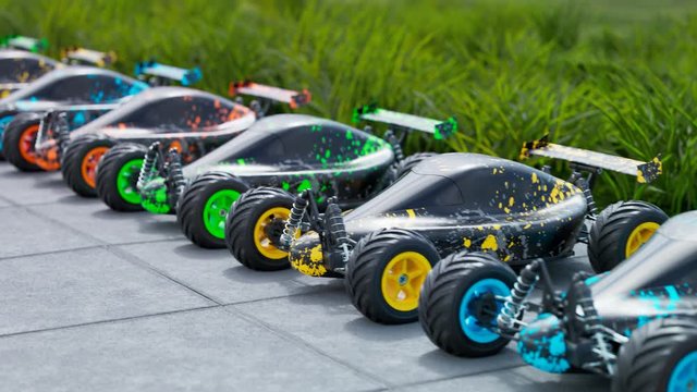 Multiple colourful remote-controlled buggy cars on a sidewalk in endless row.