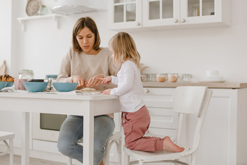 A young mother spends time with her little daughter at home.