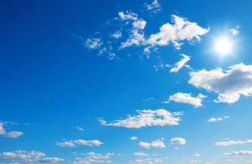 Blue sky with clouds and sun.