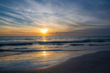Fototapeta na wymiar Golden Sunset Seascape Beach Waves Cloudy Sky