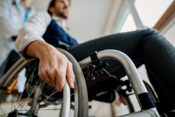 Close-up of disabled man in wheelchair and with a doctor.