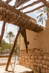 A palm tree trunk reel and leather bucket of the traditional Arab water well in Diriyah Park, Riyadh, Saudi Arabia