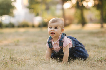 Little baby on grass in august. Adorable baby girl outside