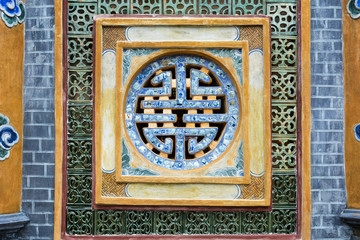 Tomb of Tu Duc in Hue, Vietnam. Detail of a window decorated with porcelain, oriental patterns