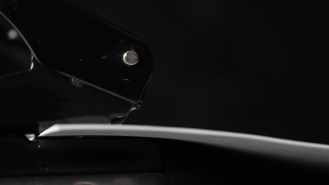 Close up view of a perforator making holes in paper sheets. Side view
