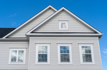 White wood accents along roof lines and above windows with using vinyl boards triangle gable...